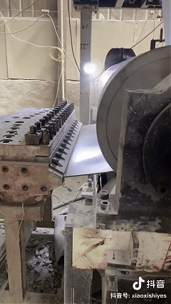 Diagram of the decorative film process for SPC wall panels, showing PVC film with wood, marble, or fabric texture printed by gravure printing, laminated onto SPC substrate with a transparent wear-resistant layer for durability and scratch resistance.