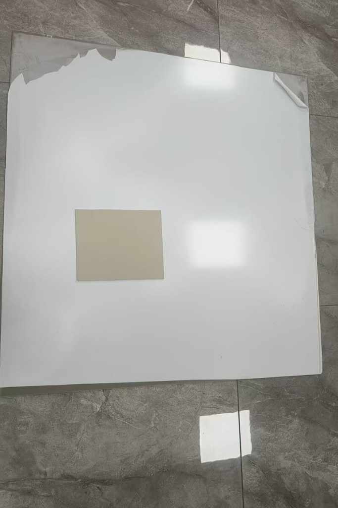 Back view of an SPC wall panel showing the hot-pressed PVC film layer that blocks wall dampness, preventing swelling, deformation, and mold growth even in humid bathrooms
